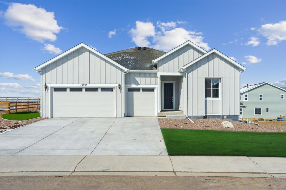 A white building with a green lawn.