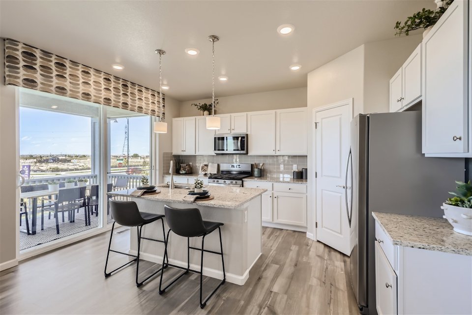 A kitchen with a table and chairs.