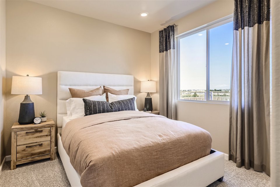 A bedroom with a large window.
