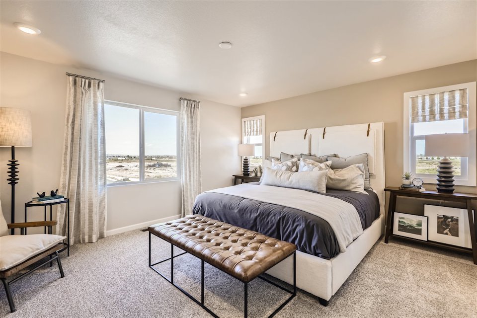 A bedroom with a large window.