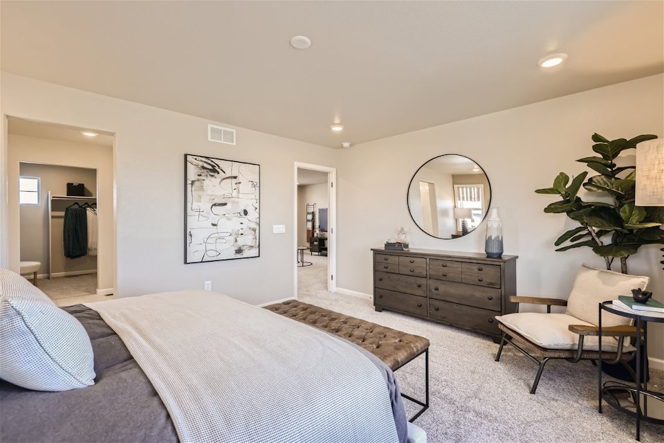 A bedroom with a bed and a mirror.