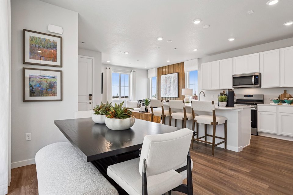 A kitchen with a dining table and chairs.