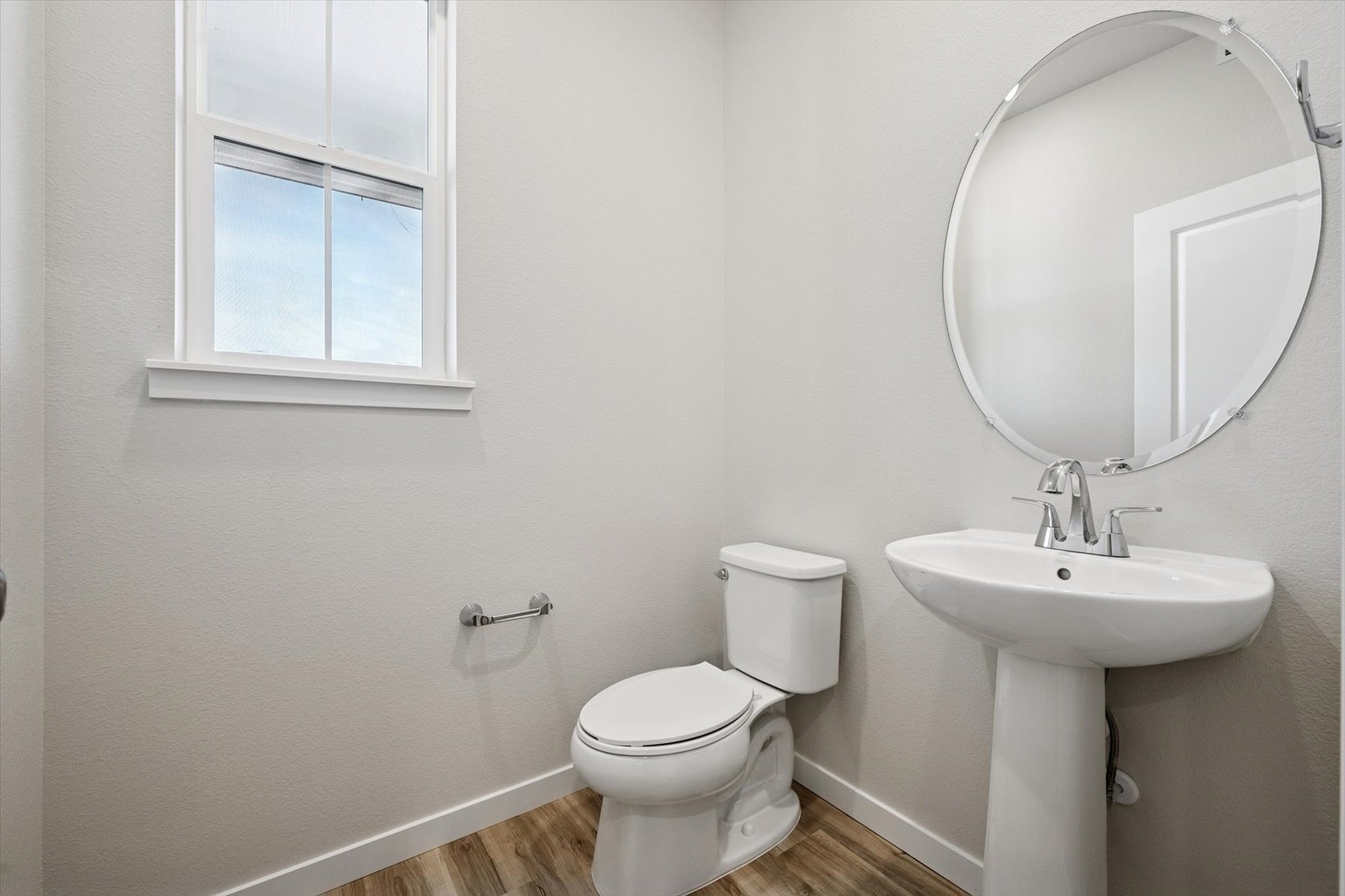 A bathroom with a round mirror.
