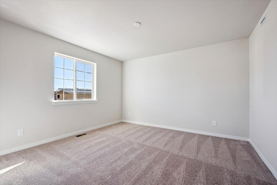 A room with a window and carpet.