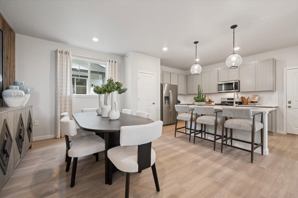 A kitchen with a dining table and chairs.