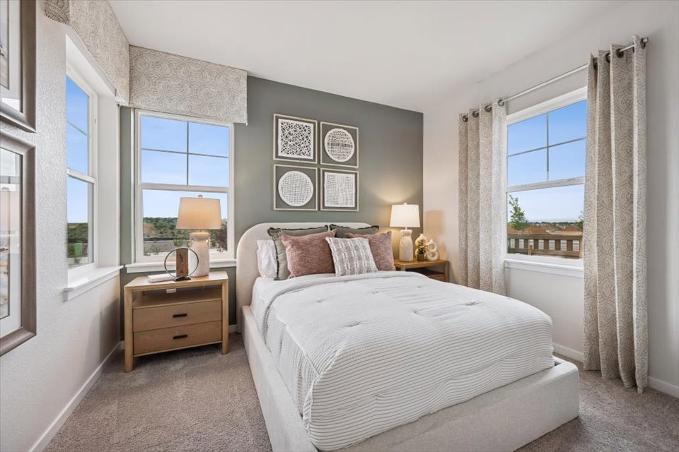 A bedroom with a bed and lamps.