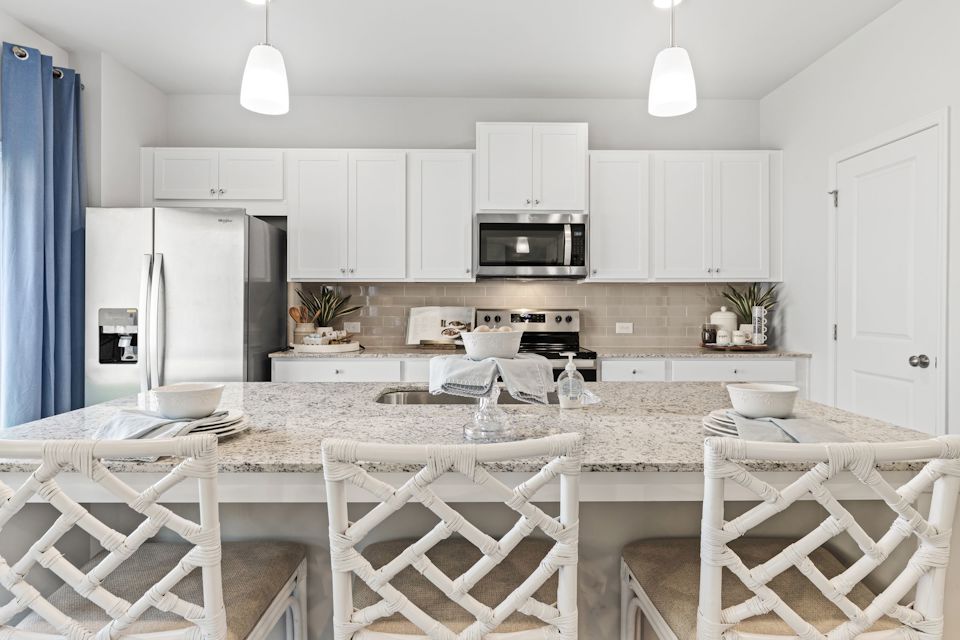 A kitchen with white cabinets.