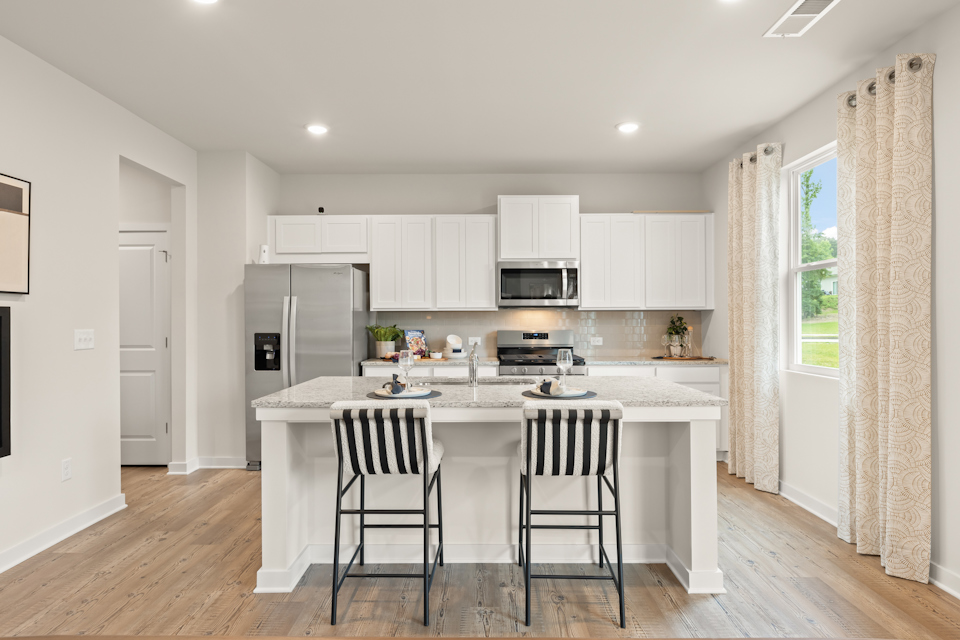 A kitchen with white cabinets.