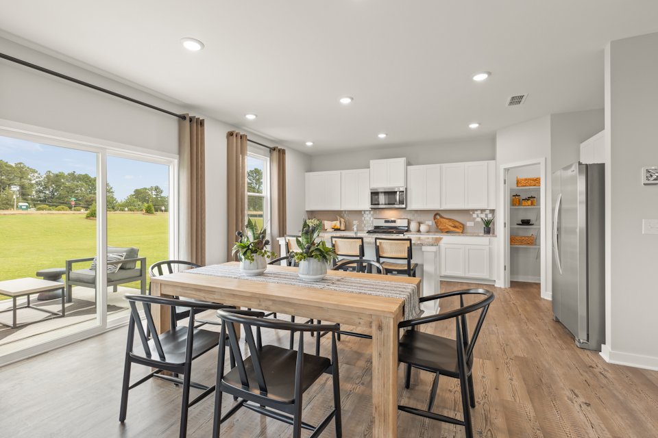 A kitchen with a table and chairs.