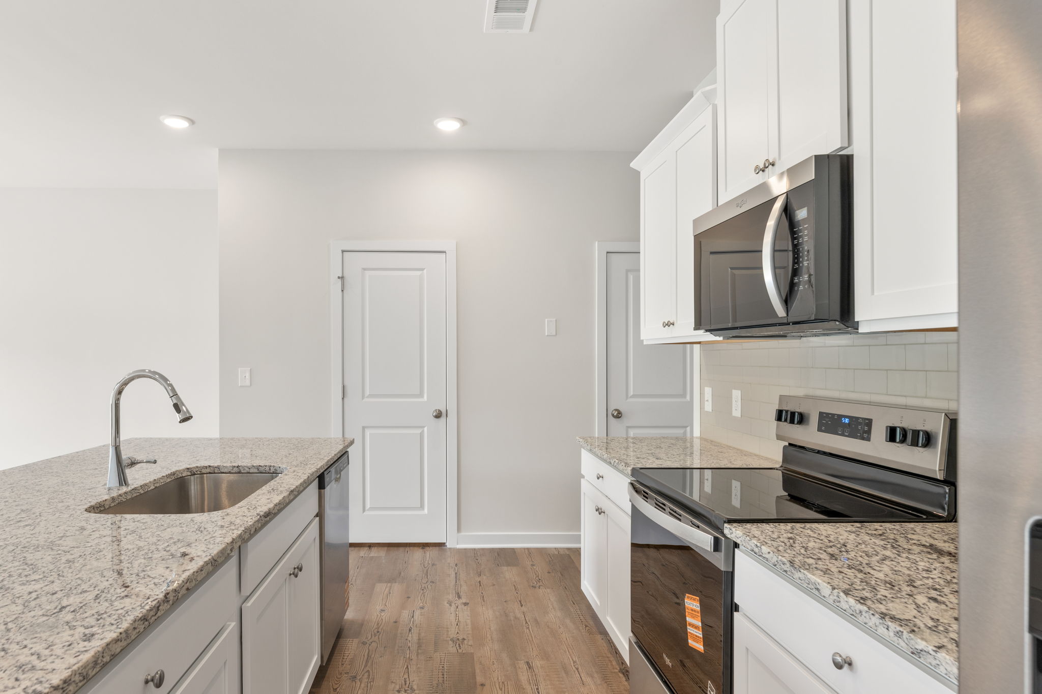 A kitchen with white cabinets.