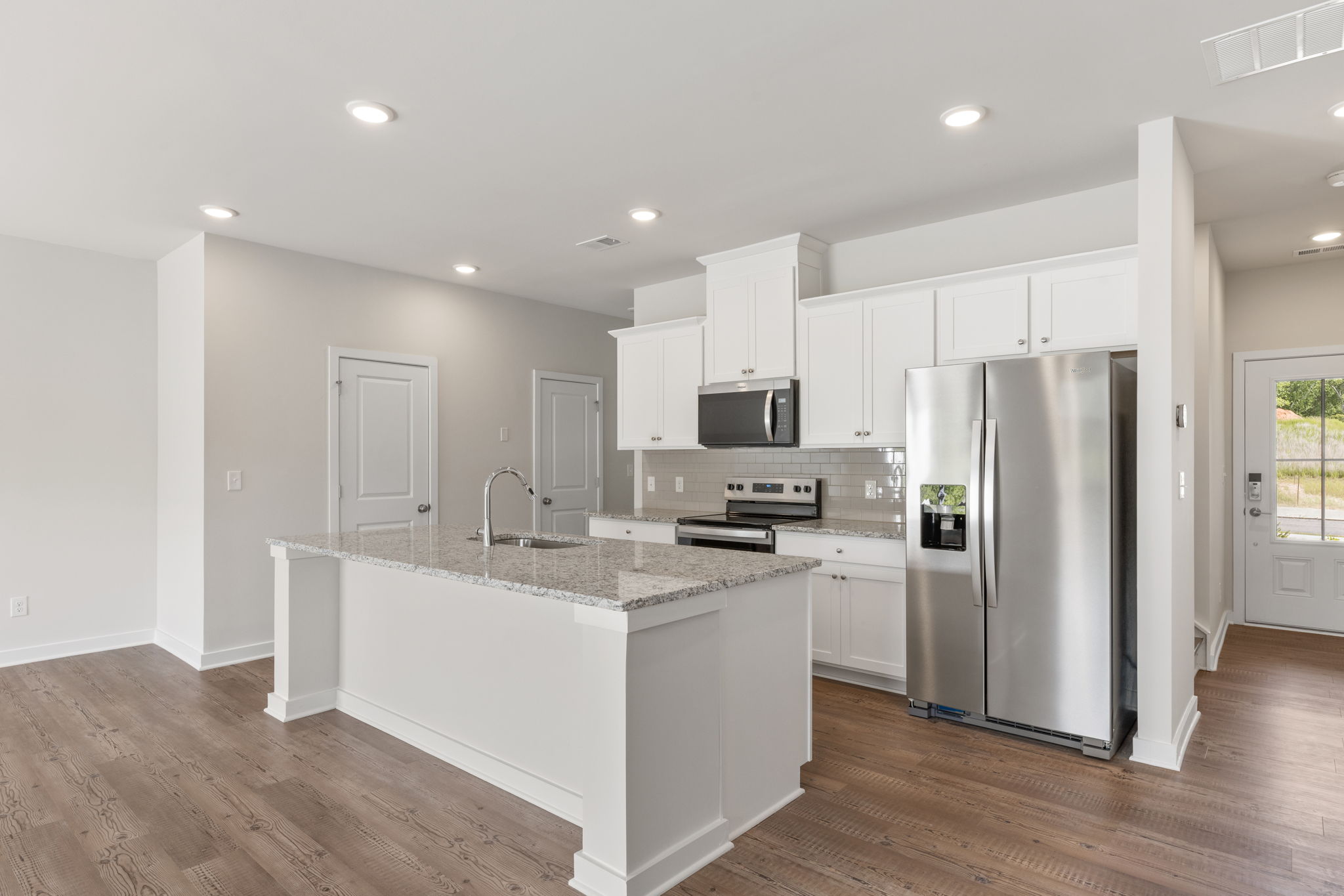 A kitchen with white cabinets.