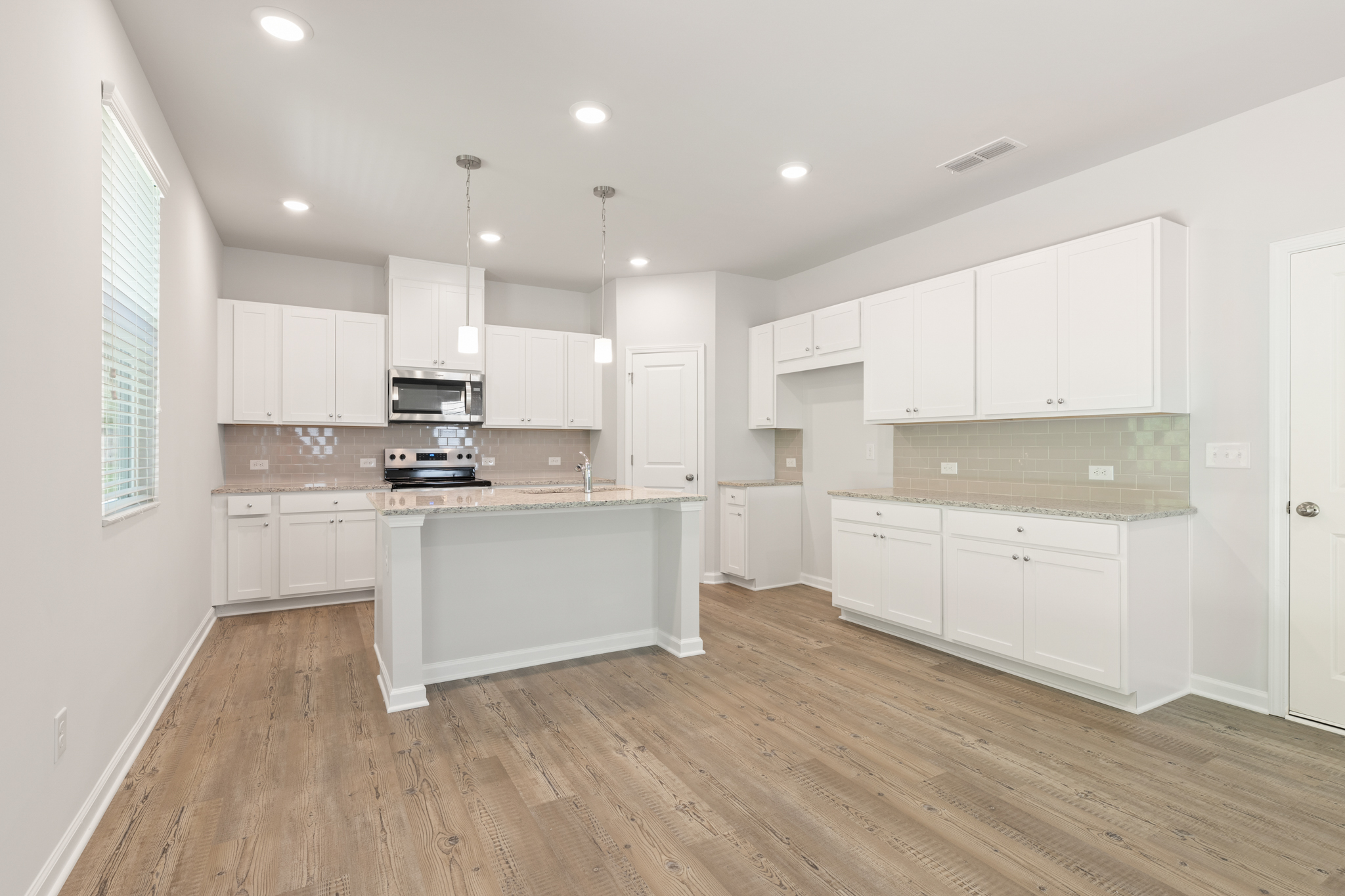 A kitchen with white cabinets.
