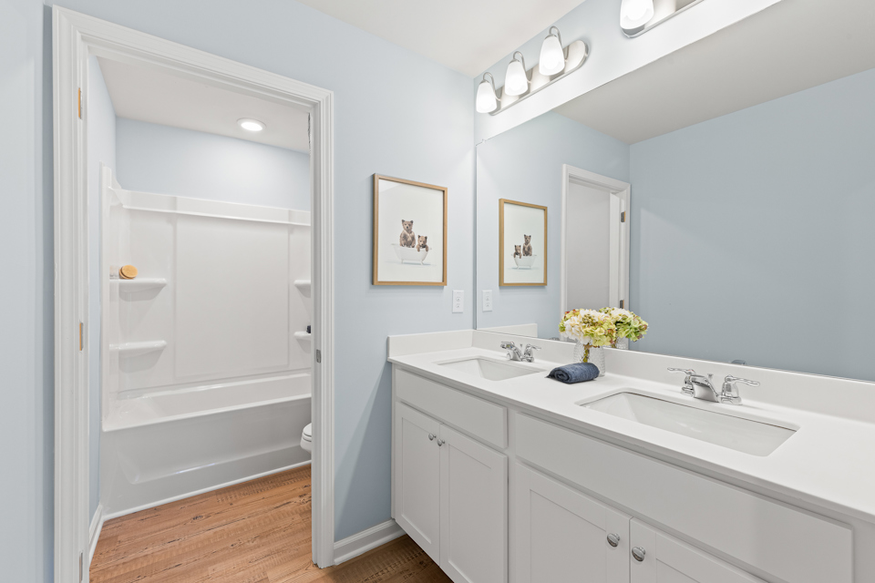 A bathroom with a tub sink and mirror.