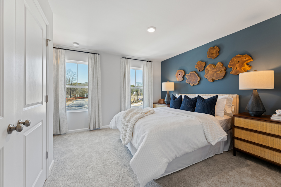 A bedroom with a bed and a lamp.