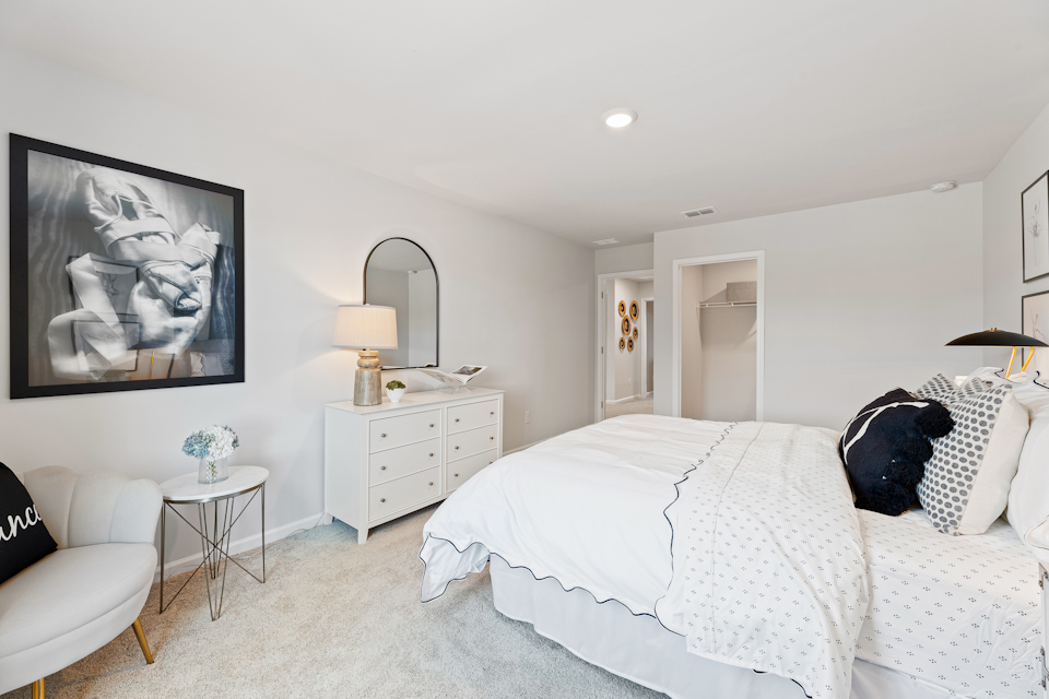 A bedroom with a bed and a mirror.