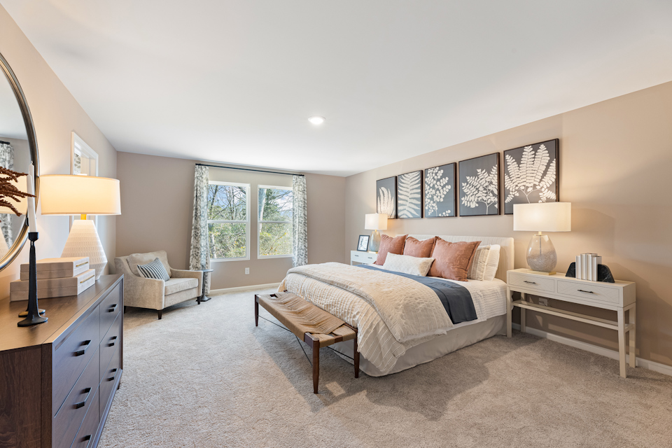 A bedroom with a bed and a bench.