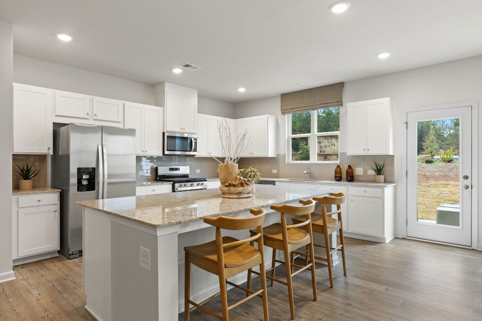 A kitchen with a dining table and a large island.