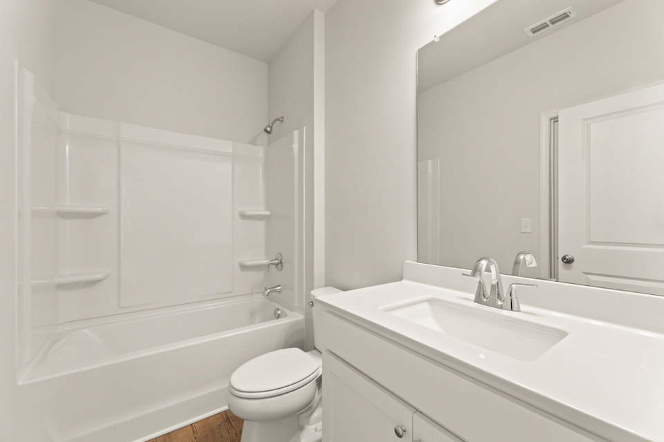 A bathroom with a tub sink and toilet.