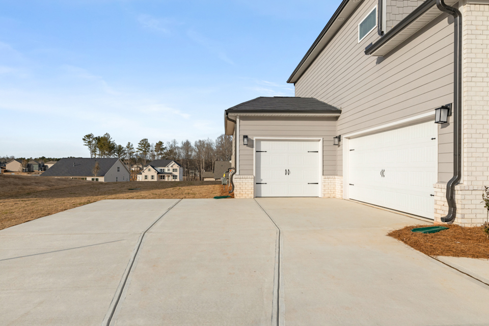 A garage with a couple of garages and a dirt yard.