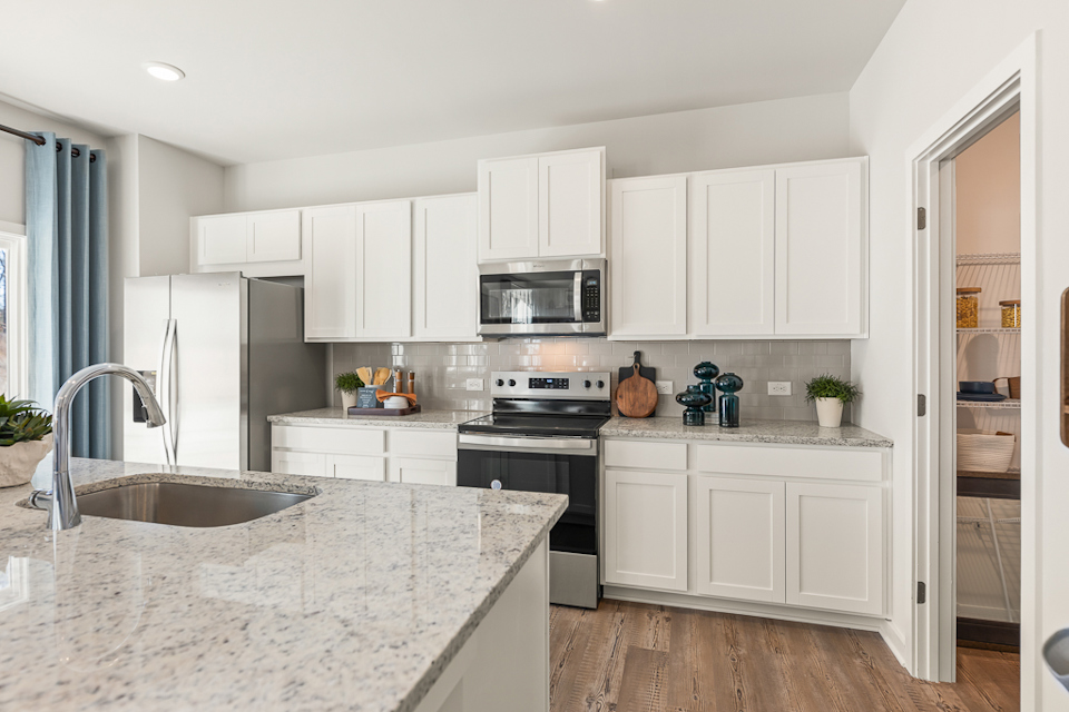 A kitchen with white cabinets.