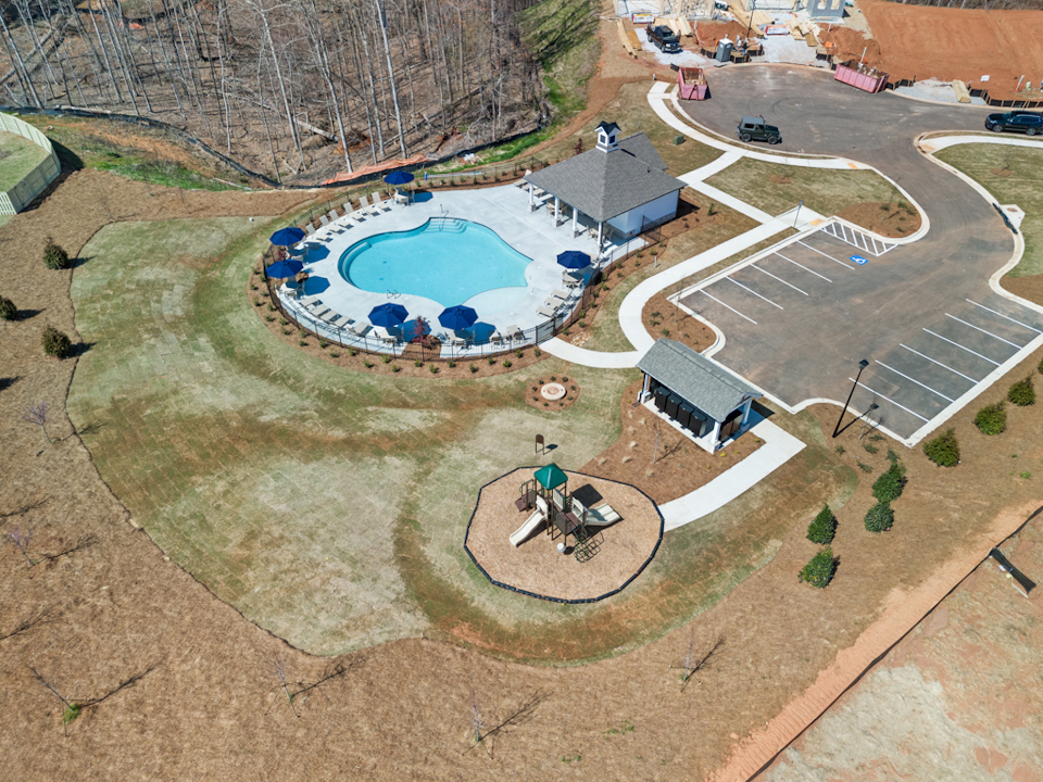 A person riding a bicycle in a courtyard with a pool.