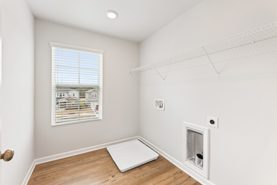 A room with a window and a rug.