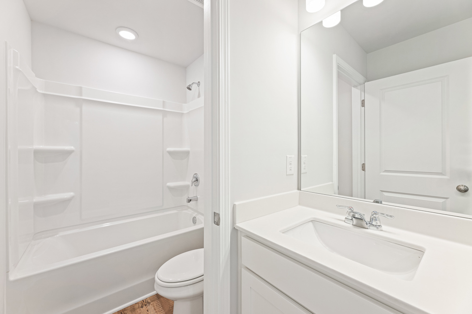 A bathroom with a tub sink and toilet.
