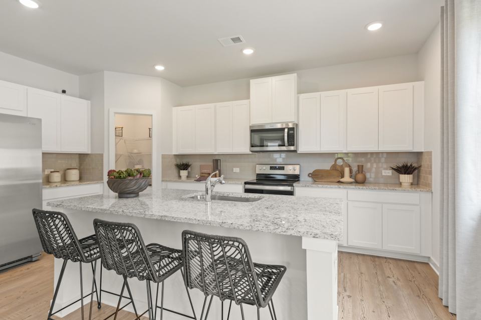 A kitchen with white cabinets.