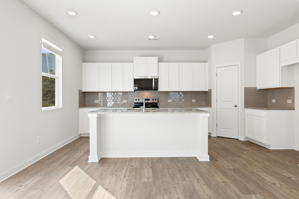 A kitchen with white cabinets.