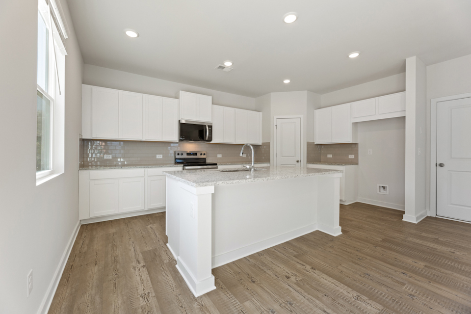 A kitchen with white cabinets.