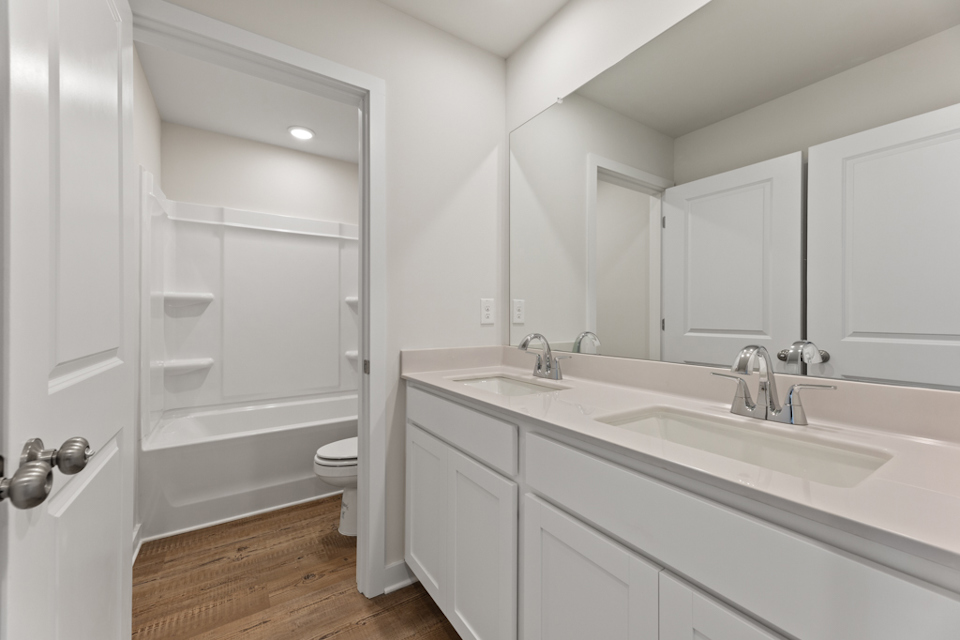 A bathroom with a tub sink and toilet.