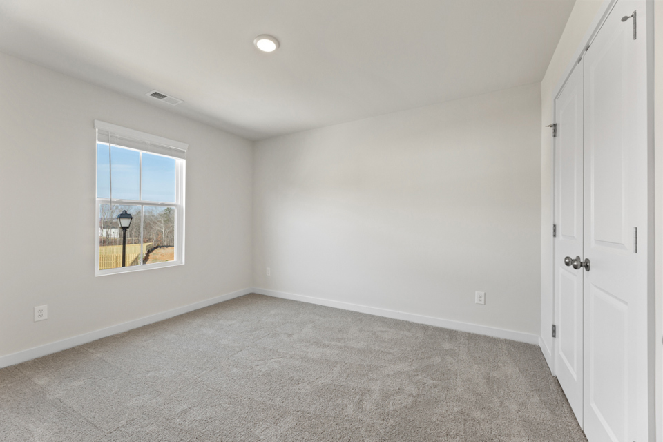 A room with a window and a carpet.