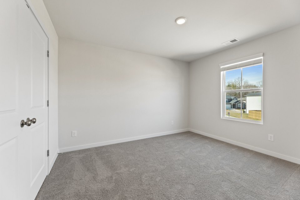 A room with a window and a carpet.