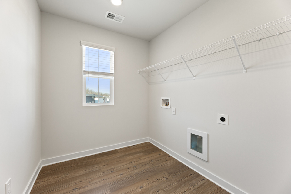 A room with a wood floor and a window with a wood floor.