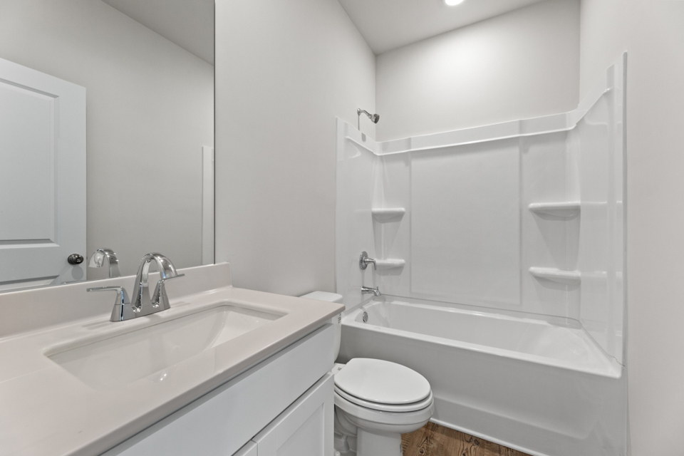 A bathroom with a tub sink and toilet.