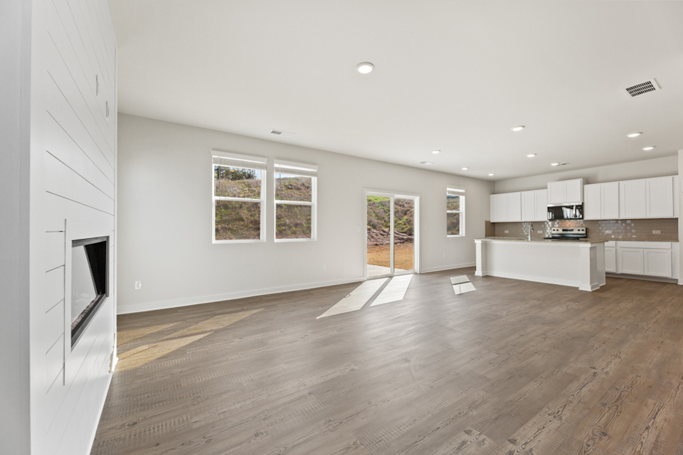 A large empty room with a wood floor and white walls.