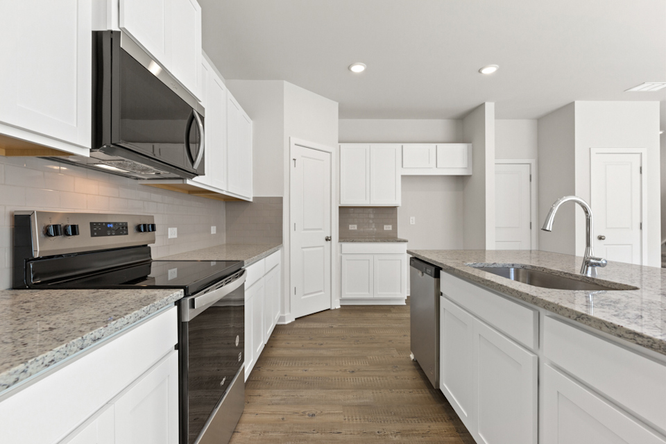 A kitchen with white cabinets.