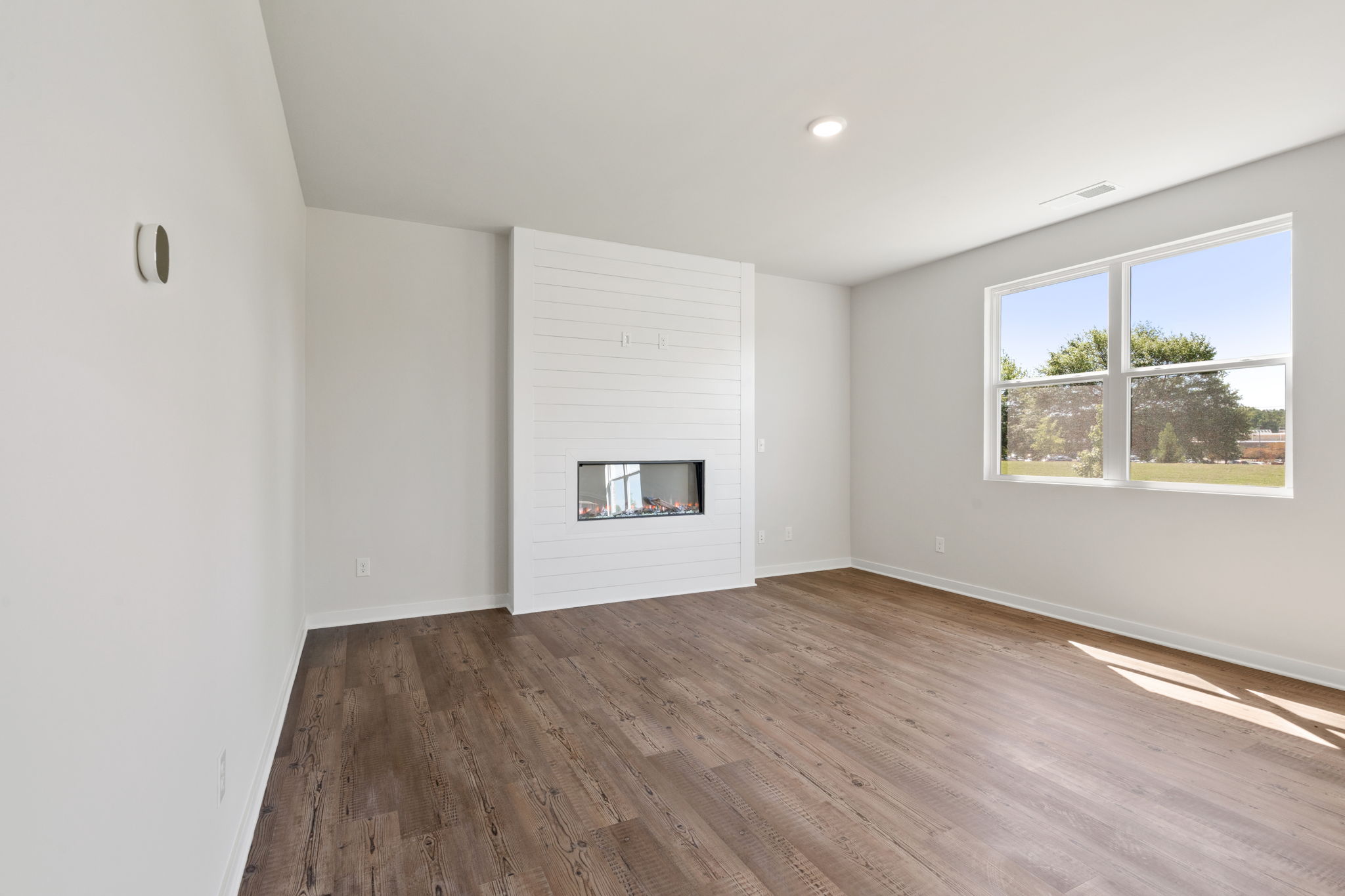 A room with a wood floor and a window.