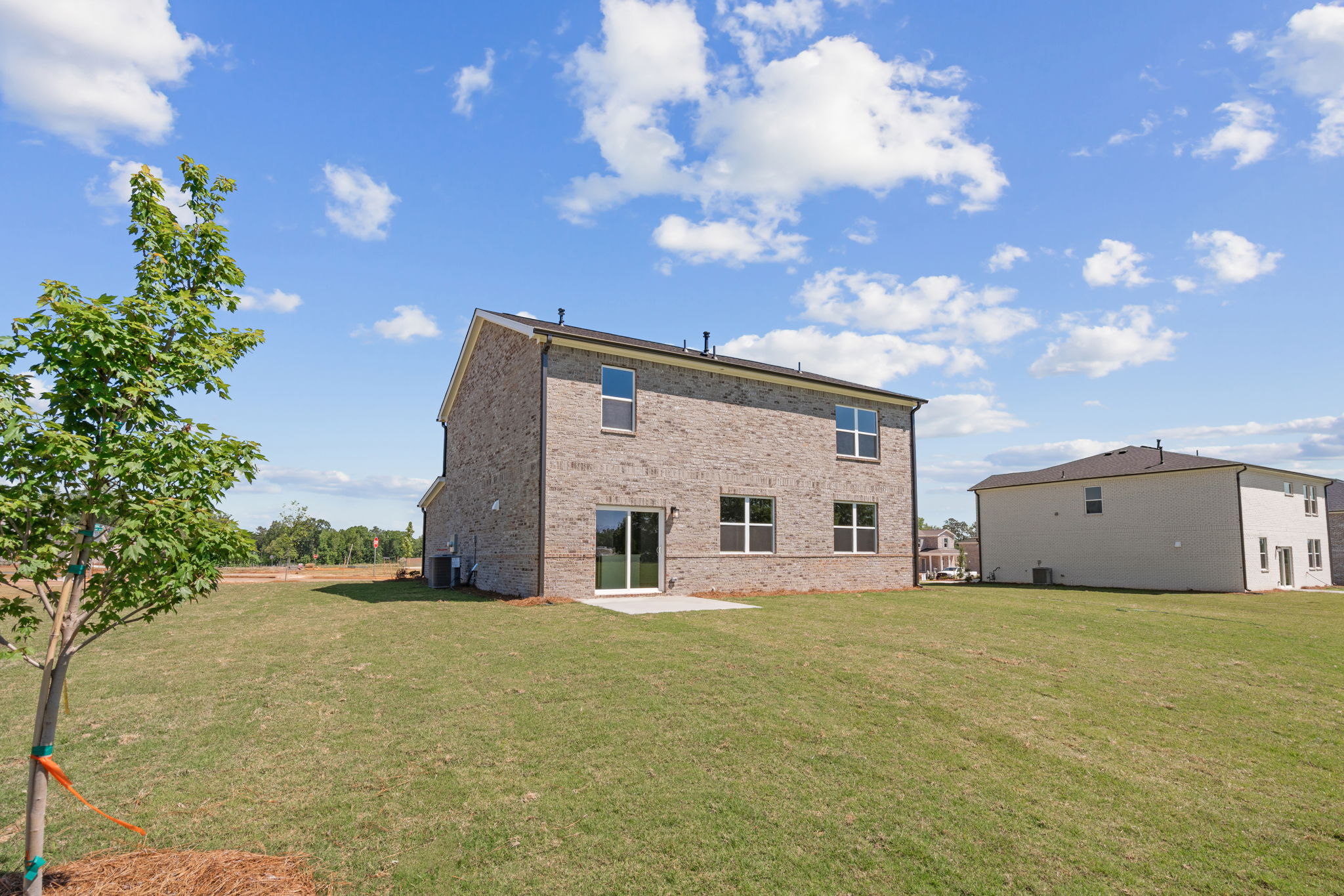 A brick building in a grassy field.