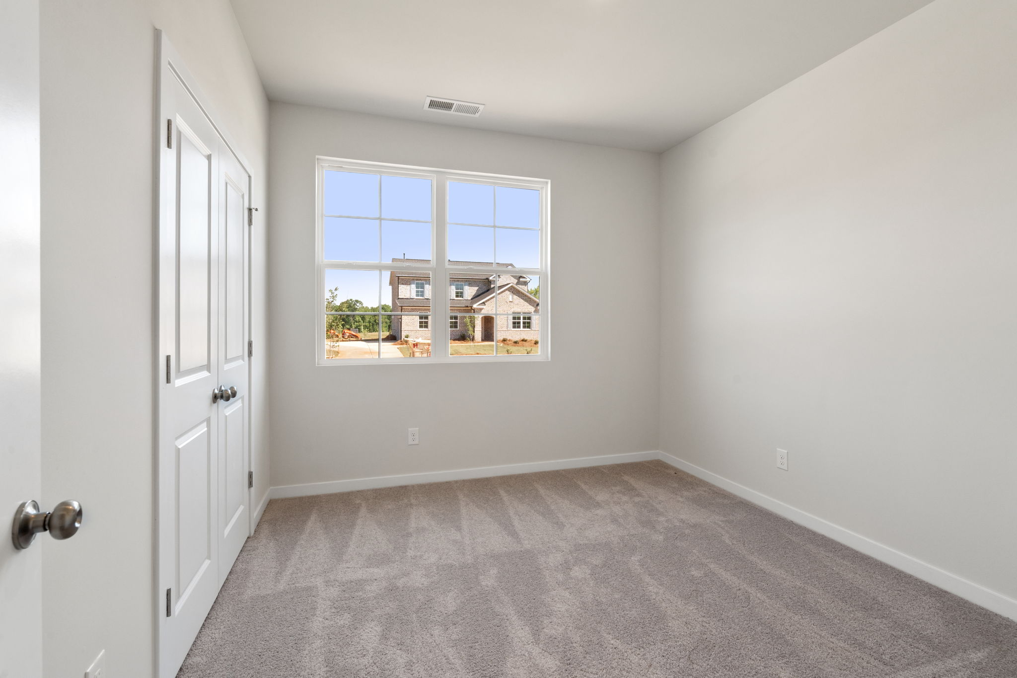 A room with a window and a carpet.
