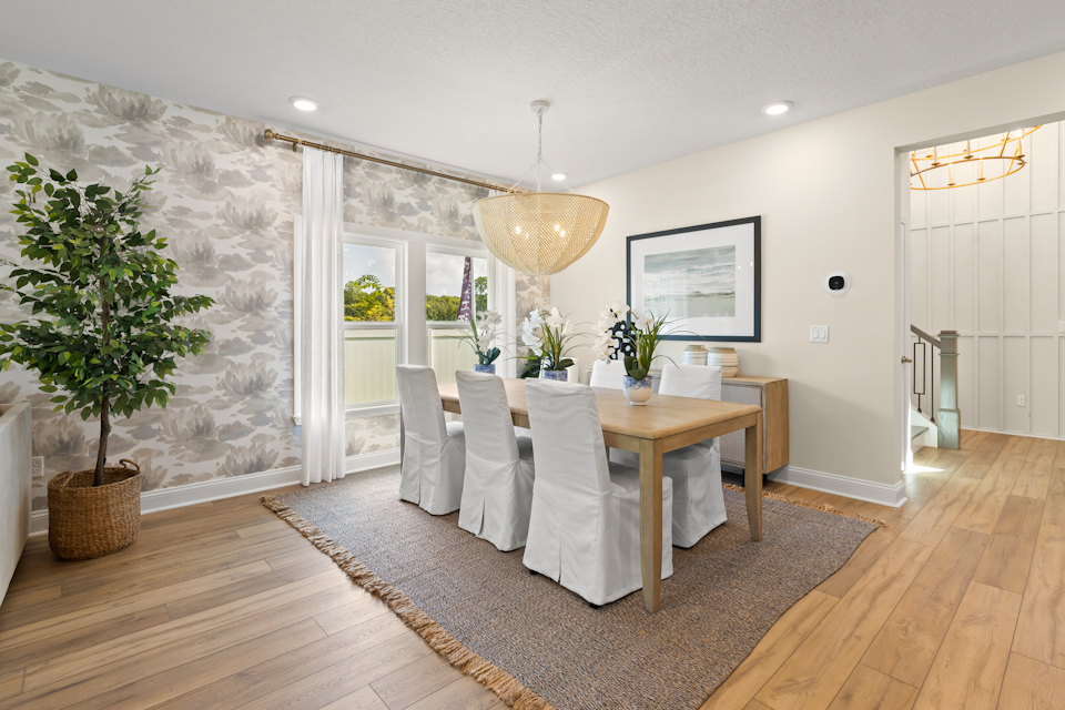 A dining room with a table and chairs.