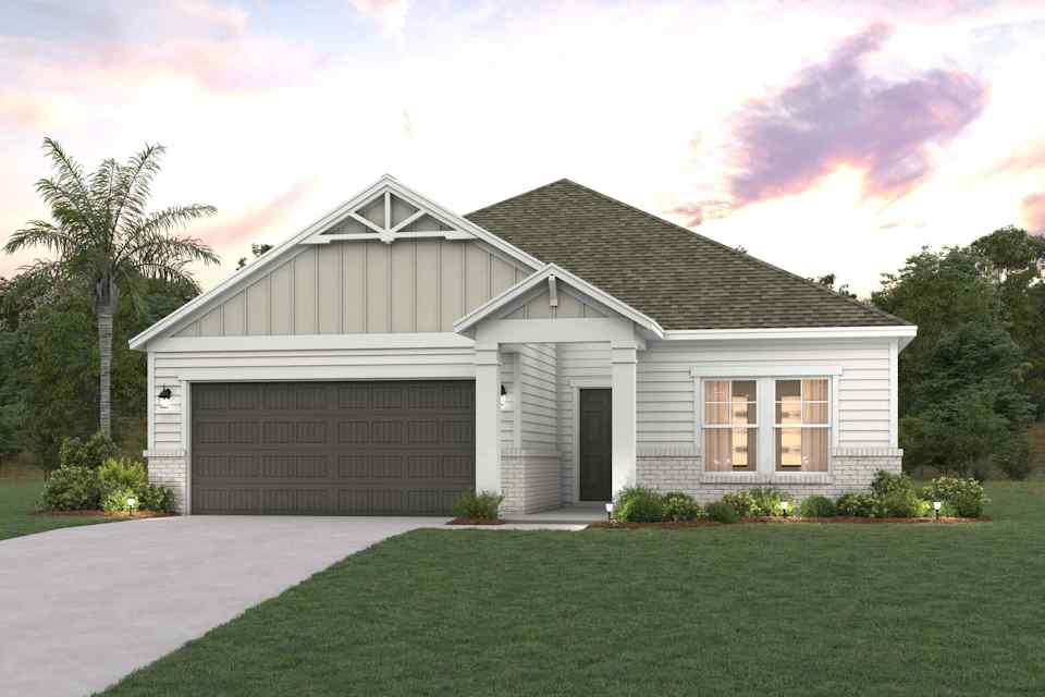 A house with a garage and a lawn in front of it.