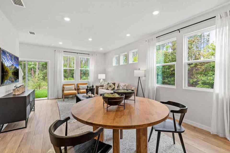 A living room with a large table and chairs.