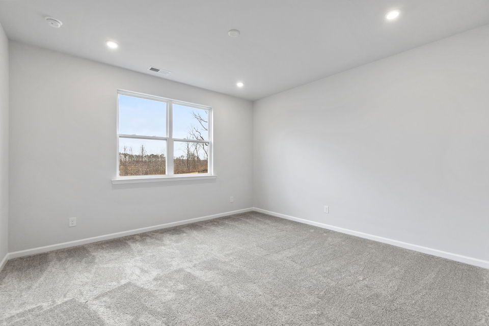 A room with a window and a carpet.