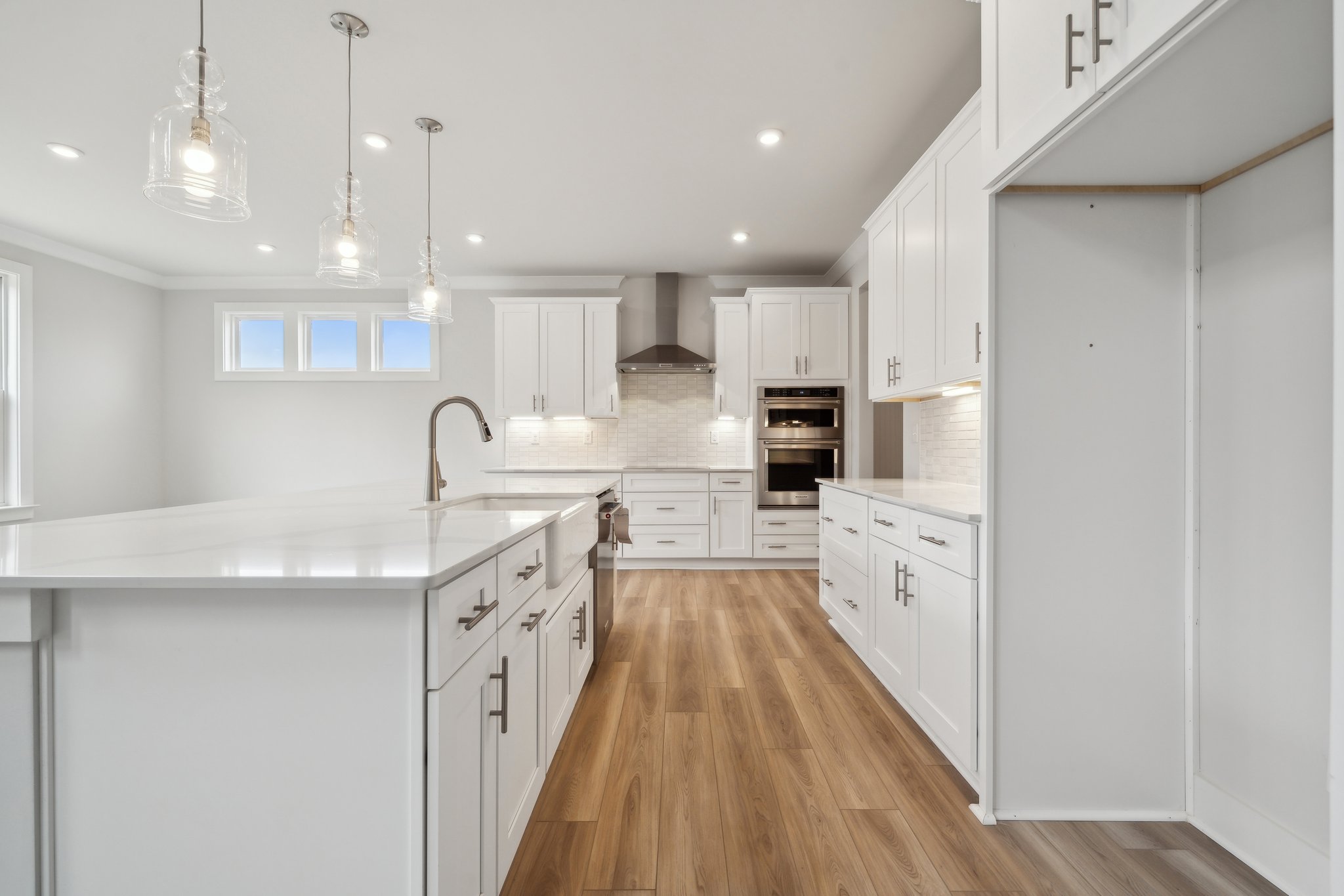 A kitchen with white cabinets.
