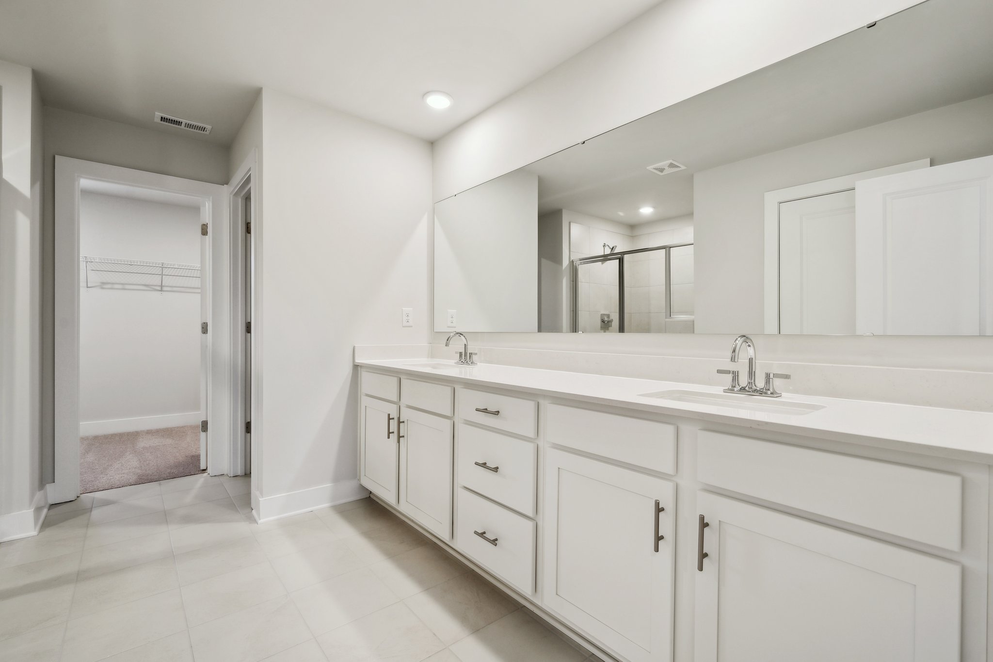 A bathroom with white cabinets.