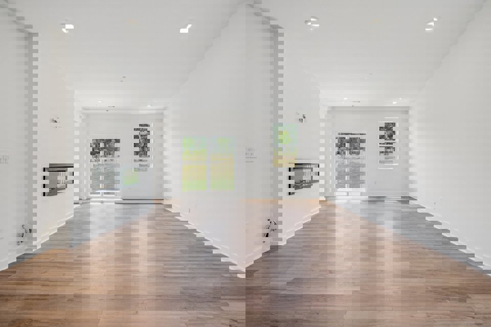 A room with white walls and a wood floor.