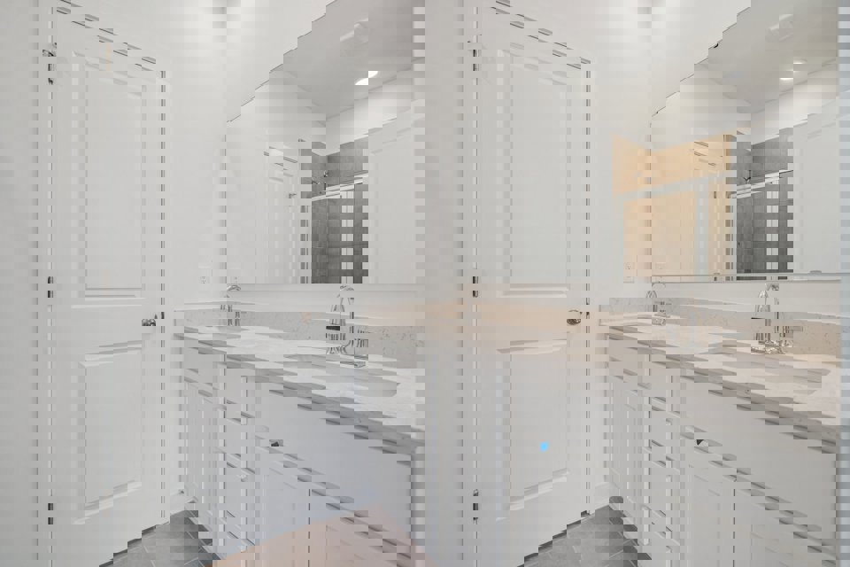 A bathroom with white cabinets.