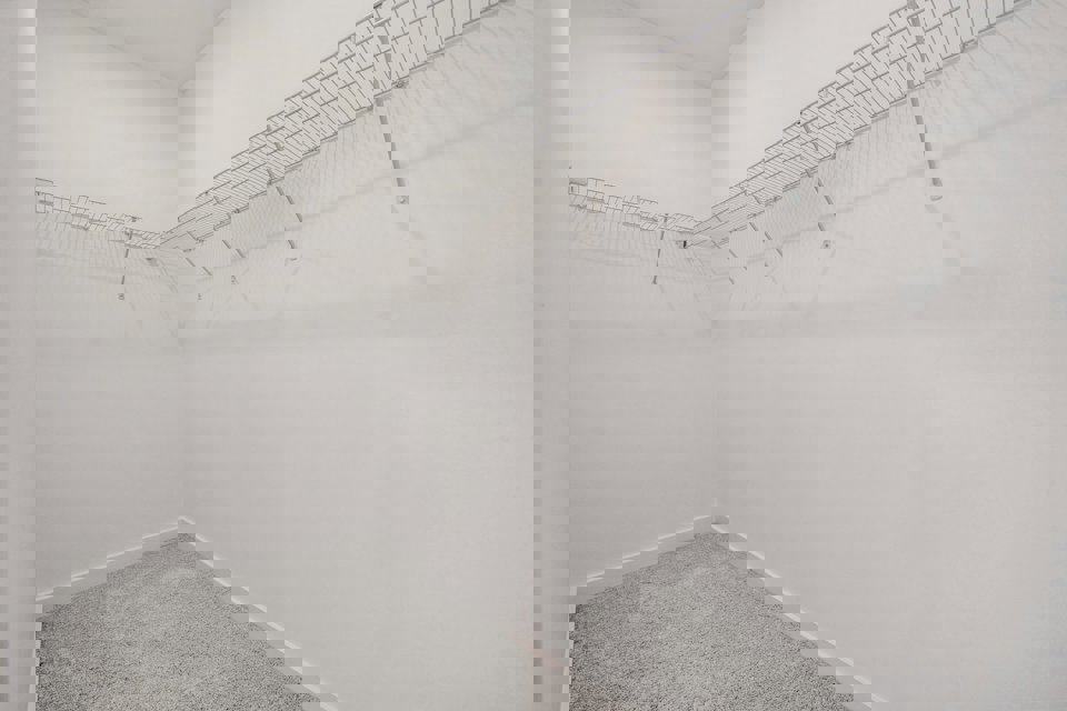 A white wall with a metal bar.