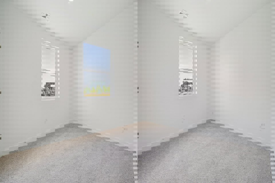 A room with a window and a white wall.